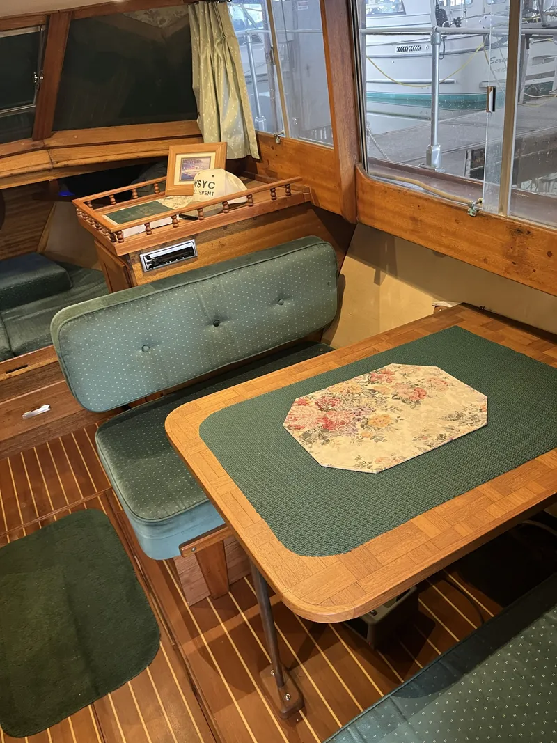 Slide: The Image of Interior of a 1959 Owens Cabin with wooden table and green upholstery. - 23