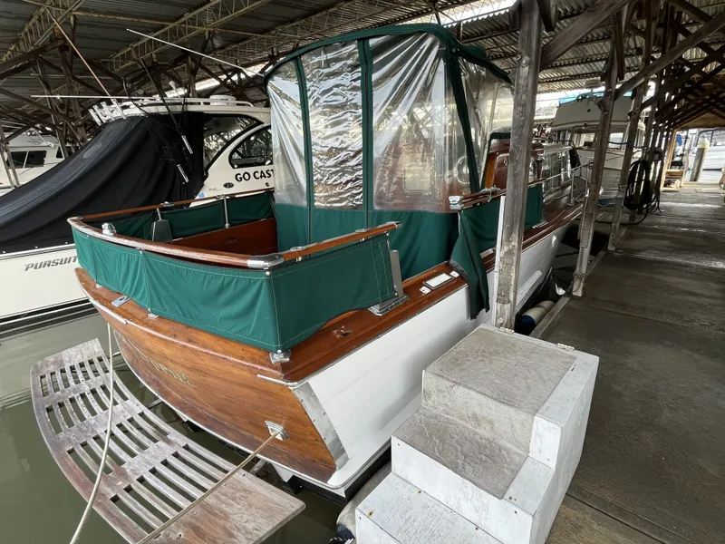 Slide: The Image of 1959 Owens Cabin boat docked with green canopy. - 4