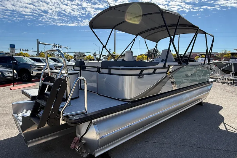 Slide: The Image of 2026 Avalon 2385 LSZ Quad Lounger Tri Toon boat with canopy, parked outdoors. - 5