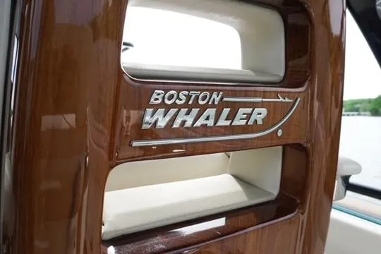 Slide: The Image of 2021 Boston Whaler 420 Outrage interior detail with logo on wooden panel. - 12