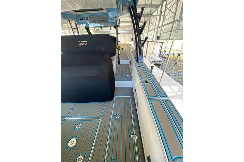 Slide: The Image of 2021 Boston Whaler 420 Outrage interior with sleek deck design in a covered dock. - 14