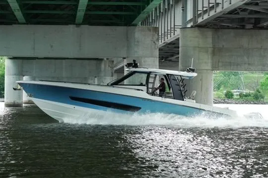 Slide: The Image of 2021 Boston Whaler 420 Outrage cruising under a bridge on a river. - 7