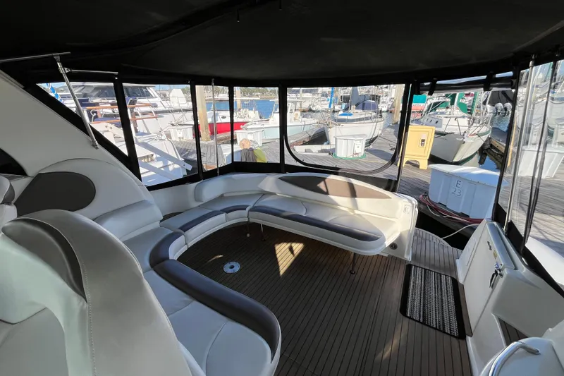 Slide: The Image of Interior view of 2003 Searay 380 yacht with spacious seating and marina backdrop. - 13