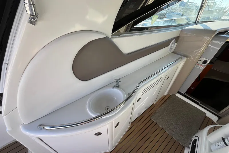 Slide: The Image of 2003 Searay 380 yacht interior with sink and cabinetry, featuring sleek design and wood flooring. - 14