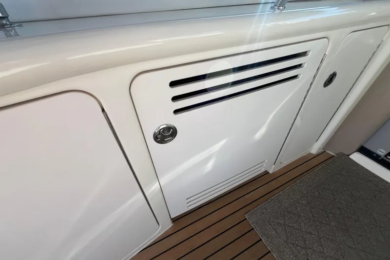 Slide: The Image of 2003 Searay 380 boat interior with white storage compartments and teak flooring. - 15
