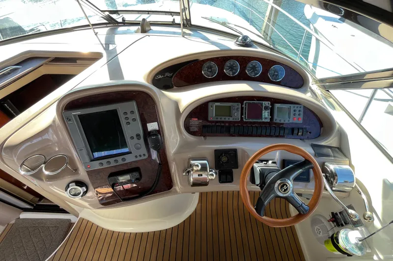 Slide: The Image of Cockpit of 2003 Searay 380 boat with navigation instruments and wooden steering wheel. - 19