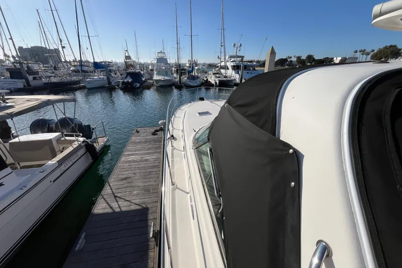 Slide: The Image of 2003 Searay 380 yacht docked at marina with other boats under clear blue sky. - 2