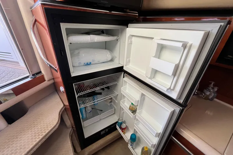 Slide: The Image of Open refrigerator inside 2003 Searay 380 yacht, showing stocked shelves and freezer. - 25