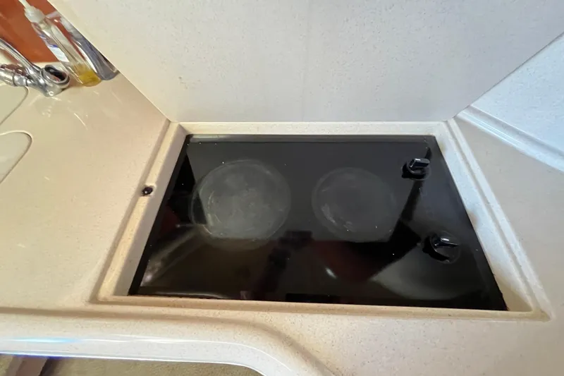 Slide: The Image of 2003 Searay 380 yacht kitchen with a sleek black stovetop. - 27