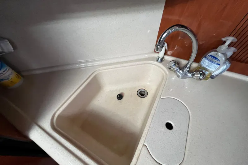 Slide: The Image of Kitchen sink area on a 2003 Searay 380 boat with faucet and soap dispenser. - 29