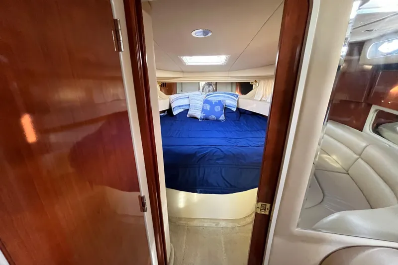 Slide: The Image of 2003 Searay 380 yacht cabin with blue bedding and wooden interior. - 33