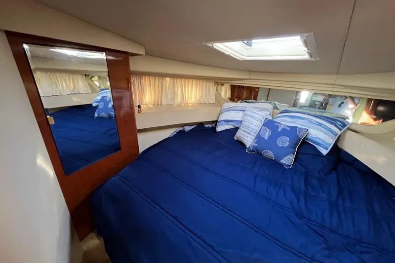 Slide: The Image of Luxurious cabin interior of 2003 Searay 380 yacht with blue bedding and decorative pillows. - 35