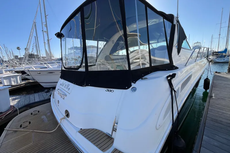 Slide: The Image of 2003 Searay 380 yacht docked at marina, featuring sleek design and black canopy. - 4