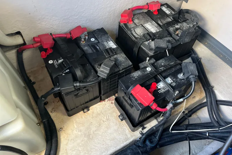 Slide: The Image of Batteries in a 2003 Searay 380 boat engine compartment, connected with red and black cables. - 43