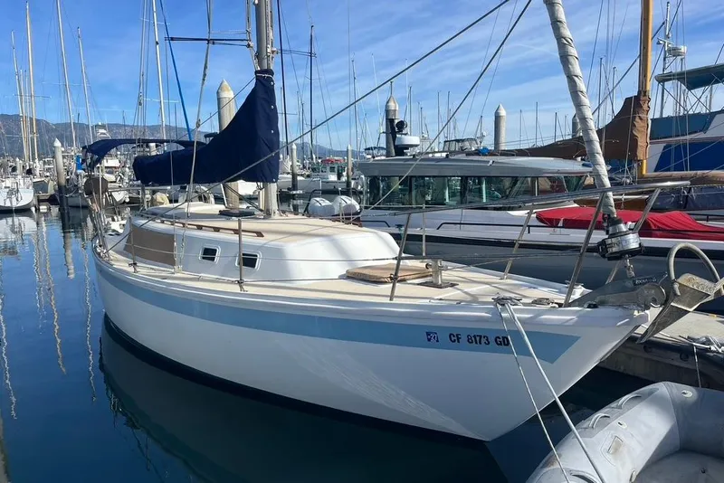 Slide: The Image of 1978 CAL 34 sailboat docked in a marina, clear blue sky reflecting on water. - 2