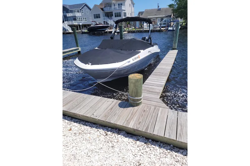 Slide: The Image of 2018 Bayliner VR5 Bowrider OB docked at a marina with waterfront homes. - 2