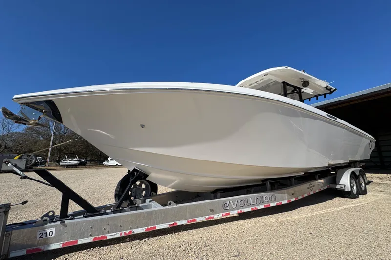 The Image of 2019 Fountain 34 Center Console boat on trailer under clear blue sky. - 0