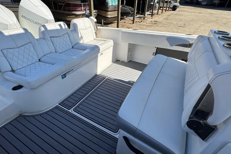 Slide: The Image of 2019 Fountain 34 Center Console boat interior with white seating and gray flooring. - 19