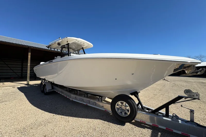 Slide: The Image of 2019 Fountain 34 Center Console boat on trailer under clear blue sky. - 2