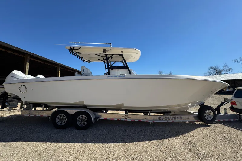 Slide: The Image of 2019 Fountain 34 Center Console boat on trailer under clear blue sky. - 3