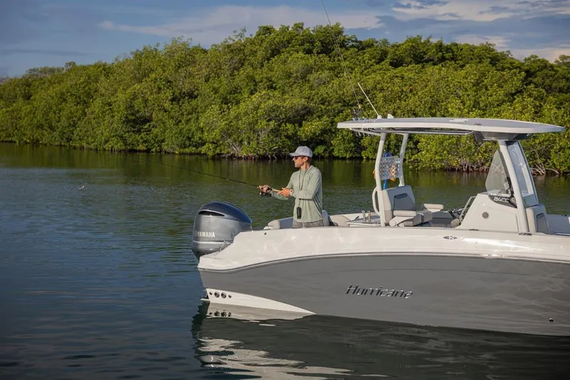 Slide: The Image of 2026 Hurricane Center Console 24 OB boat with person fishing in serene waters. - 13