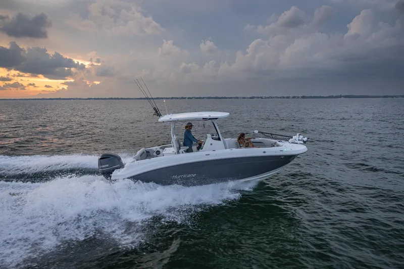Slide: The Image of 2026 Hurricane Center Console 24 OB boat cruising on open water at sunset. - 18