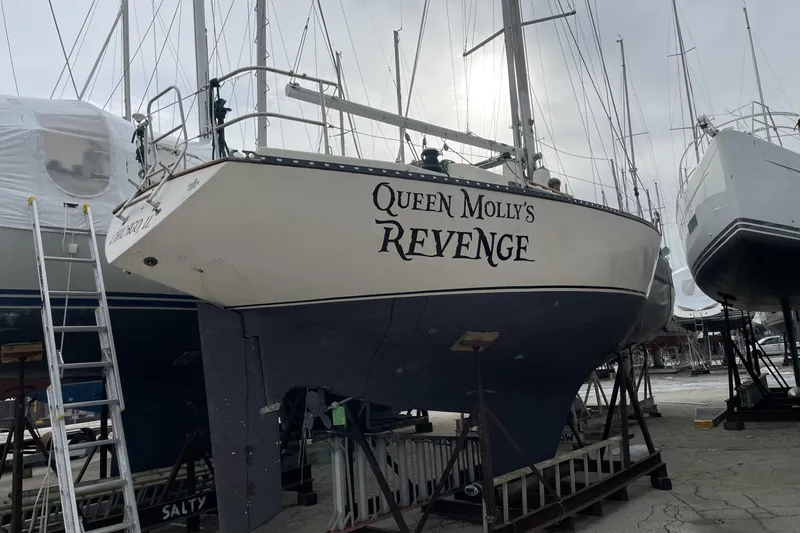 Slide: The Image of 1978 Kettenburg 32 sailboat "Queen Molly's Revenge" on dry dock, surrounded by other boats. - 3