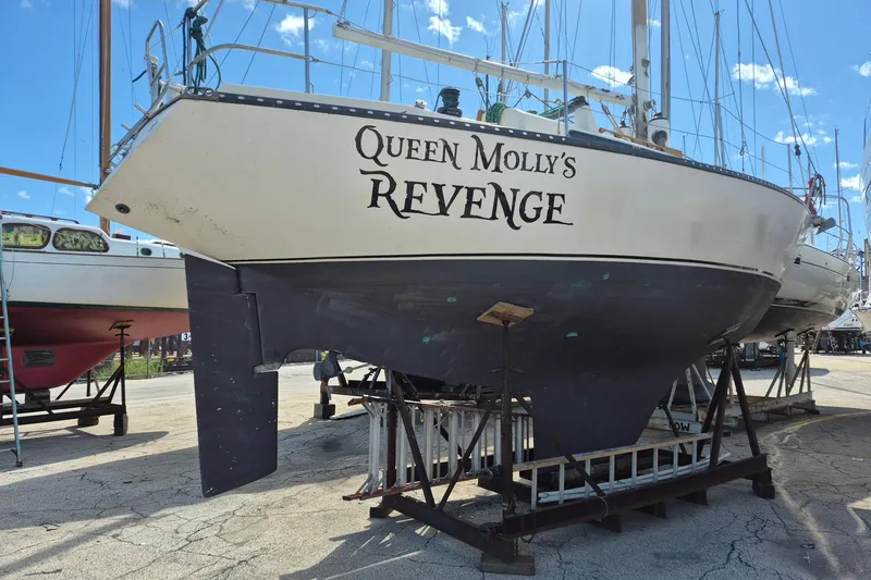 Slide: The Image of 1978 Kettenburg 32 sailboat "Queen Molly's Revenge" on dry dock, blue sky background. - 4
