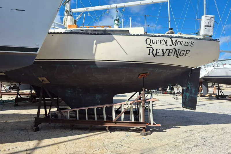 Slide: The Image of 1978 Kettenburg 32 sailboat "Queen Molly's Revenge" on dry dock, blue sky background. - 6