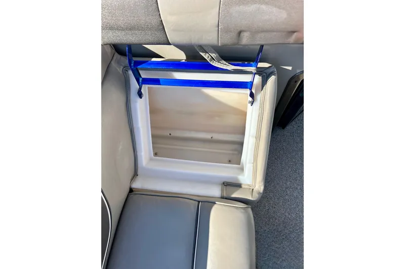 Slide: The Image of Open storage compartment in 2007 Premier 250 Intrigue boat seat, featuring blue straps and gray upholstery. - 20
