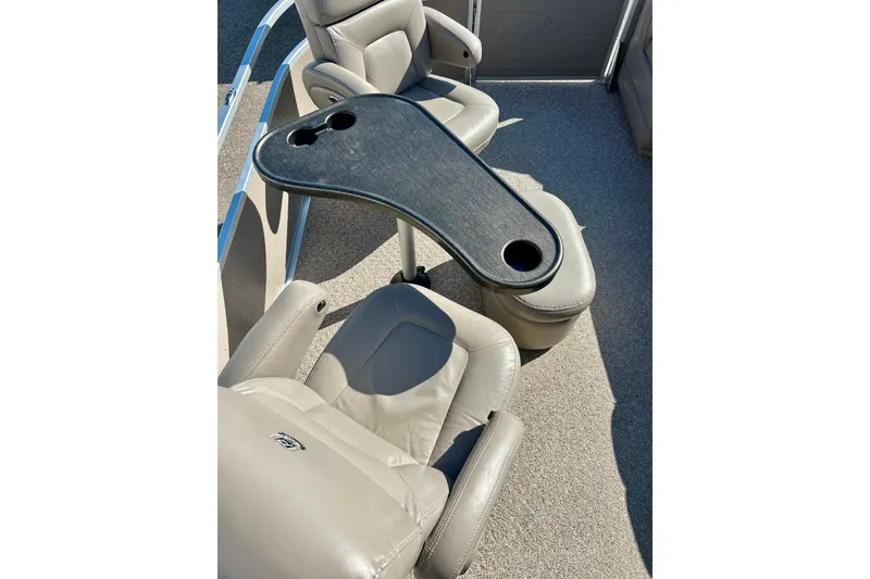 Slide: The Image of Premier 250 Intrigue 2007 boat interior with beige seats and a table with cup holders. - 33