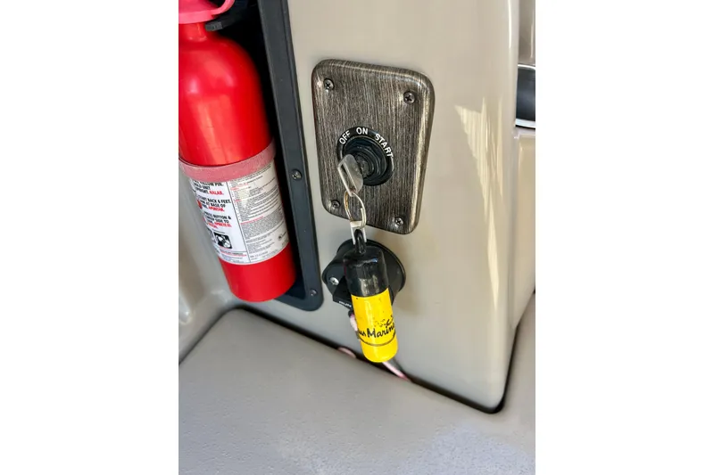 Slide: The Image of Key ignition and fire extinguisher on 2007 Premier 250 Intrigue boat dashboard. - 54