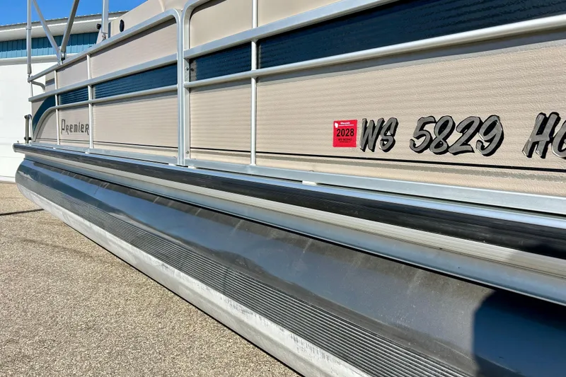 Slide: The Image of 2007 Premier 250 Intrigue pontoon boat with registration sticker and visible railing. - 6