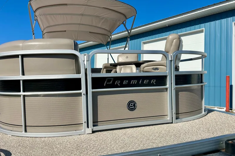 Slide: The Image of 2007 Premier 250 Intrigue pontoon boat with canopy, parked near a blue building. - 7