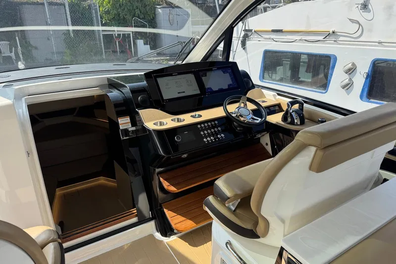 Slide: The Image of 2022 Sea Ray Sundancer 370 Outboard helm with modern controls and comfortable seating. - 18