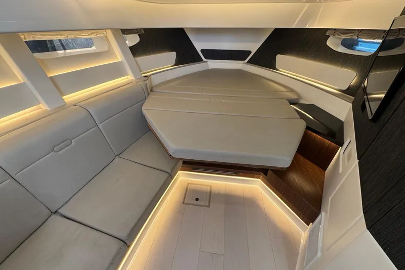 Slide: The Image of 2022 Sea Ray Sundancer 370 Outboard cabin interior with modern seating and ambient lighting. - 22