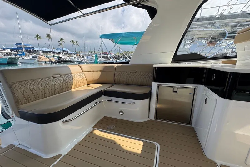 Slide: The Image of 2022 Sea Ray Sundancer 370 Outboard interior with seating and kitchenette, docked at marina. - 26