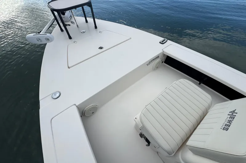 Slide: The Image of 2018 Hewes Redfisher 18 boat interior with seating and storage, on calm water. - 5
