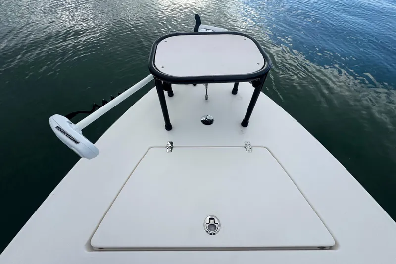Slide: The Image of 2018 Hewes Redfisher 18 boat deck with trolling motor on calm water. - 6