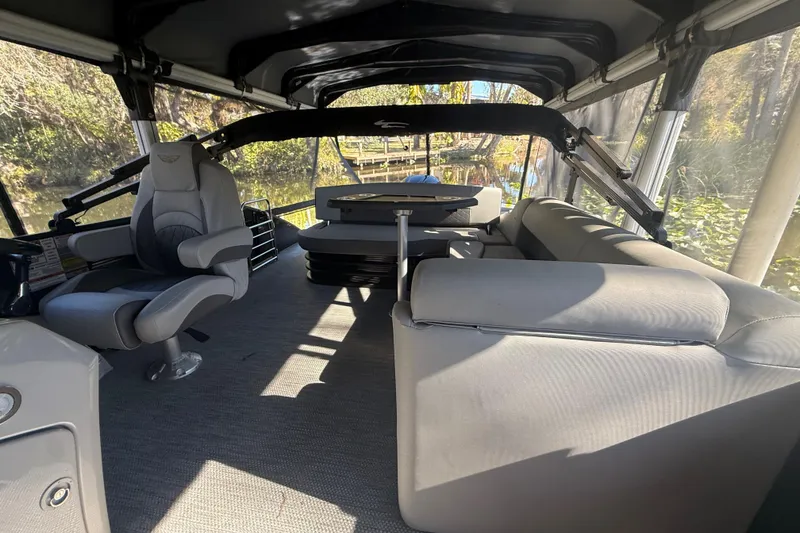 Slide: The Image of 2024 Bennington L Line boat interior with seating and helm, under canopy. - 16