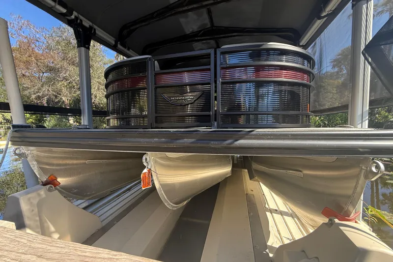 Slide: The Image of 2024 Bennington L Line pontoon boat, docked, showcasing sleek design and sturdy construction. - 2