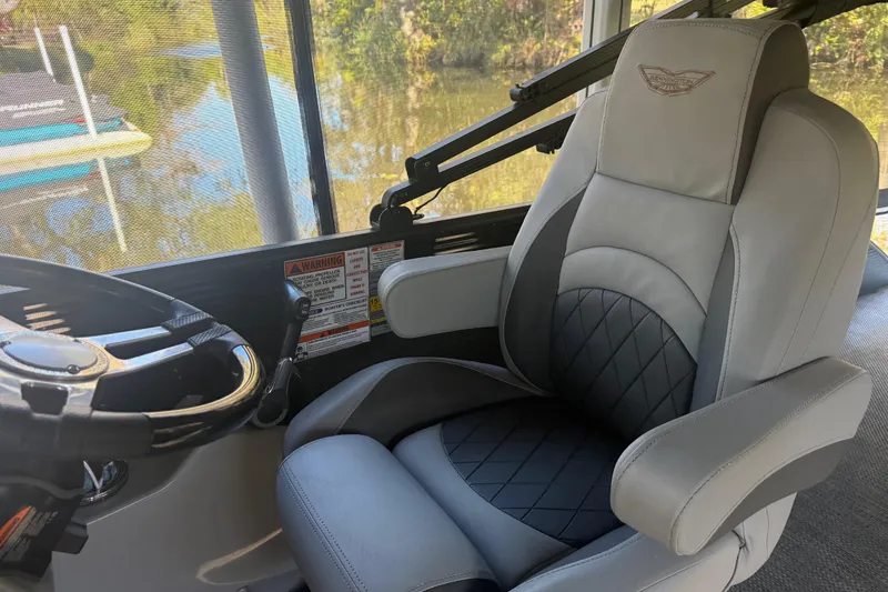 Slide: The Image of 2024 Bennington L Line boat interior with luxury captain's chair and steering wheel. - 20