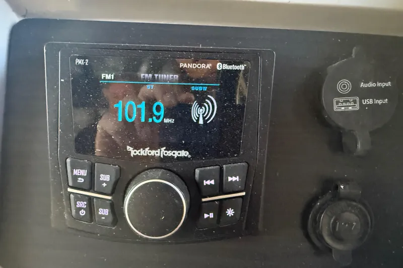 Slide: The Image of 2024 Bennington L Line audio system with Rockford Fosgate display, showing FM 101.9 MHz. - 27