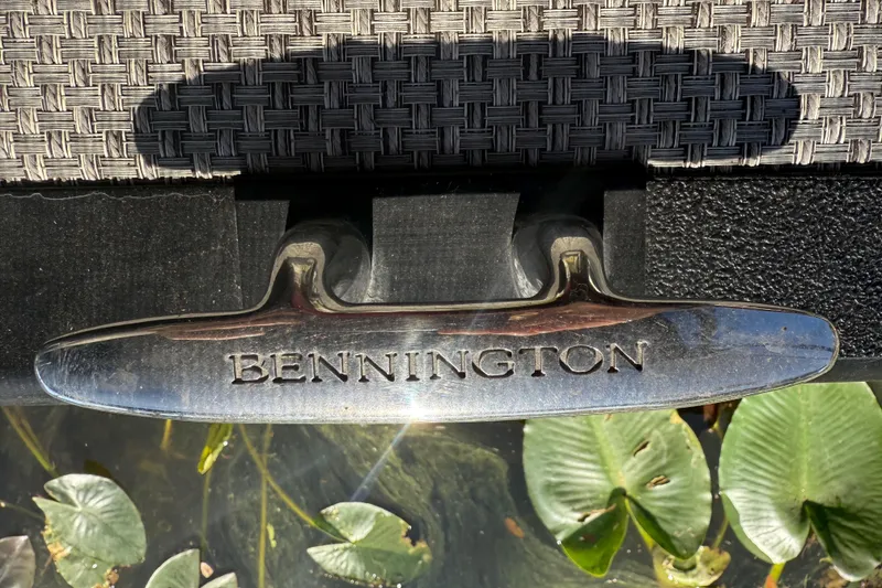 Slide: The Image of Chrome cleat on 2024 Bennington L Line boat, with woven texture and water plants. - 30