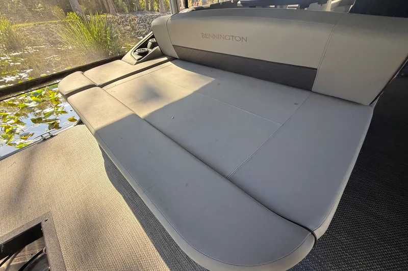 Slide: The Image of 2024 Bennington L Line boat interior with luxurious seating and scenic water view. - 33