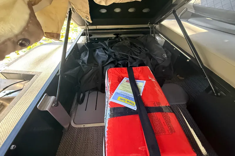 Slide: The Image of 2024 Bennington L Line storage compartment with red package and black cover. - 34