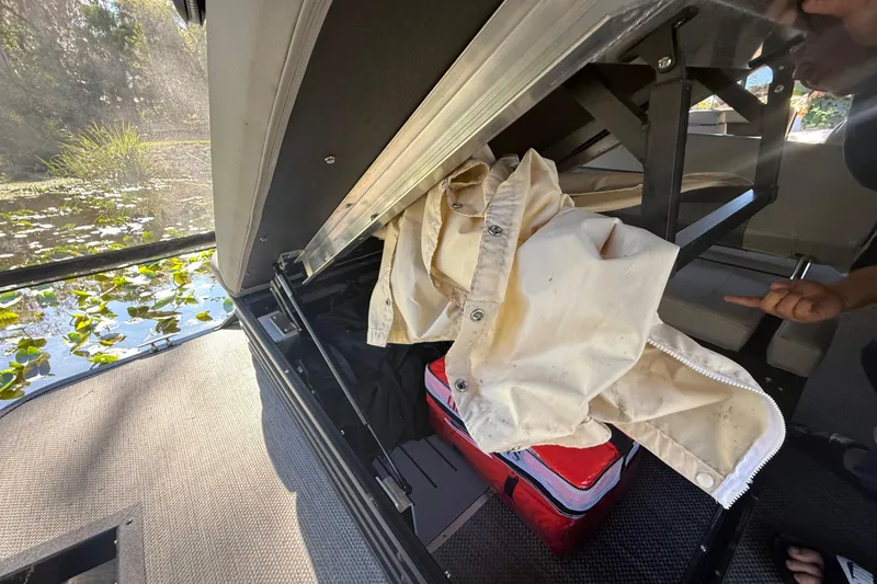 Slide: The Image of 2024 Bennington L Line boat storage compartment with jacket and cooler. - 35