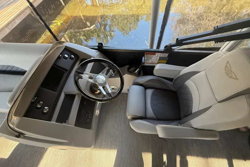Slide: The Image of 2024 Bennington L Line boat interior with steering wheel and captain's chair. - 9