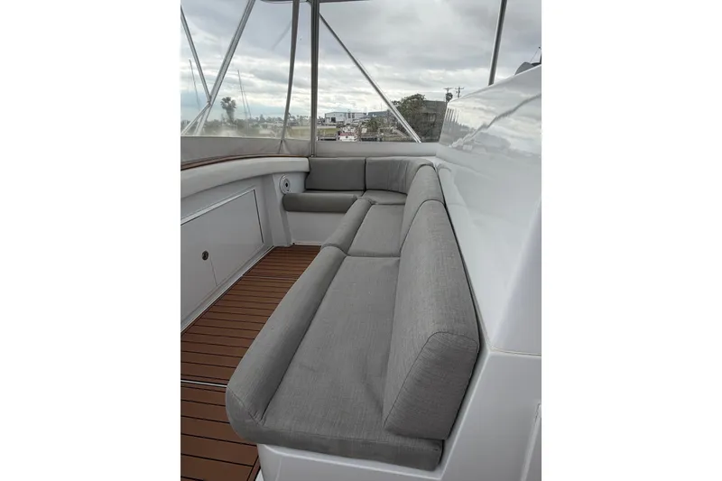 Slide: The Image of 1985 Bertram 54 Convertible boat interior with gray seating and wooden flooring. - 15