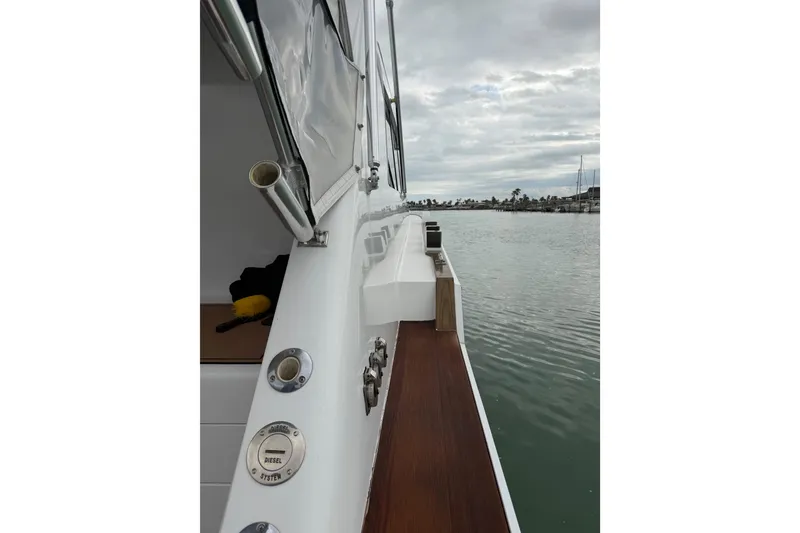 Slide: The Image of 1985 Bertram 54 Convertible yacht deck view with calm waters and cloudy sky. - 19
